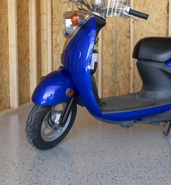 blue scooter in garage with gray flaked epoxy floor coating