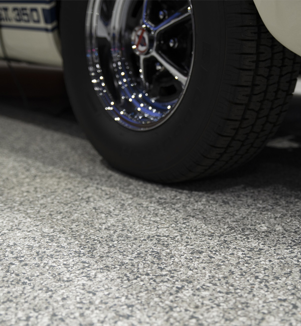 upclose view of car and gray flaked epoxy floor coating